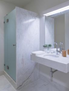 a white bathroom with a sink and a shower at República Bed & Breakfast in Lisbon