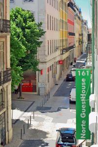 una calle de la ciudad con edificios y una señal verde en Norte Guest House en Lisboa