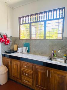 a kitchen counter with a sink and a window at Oracle Residence in Anuradhapura