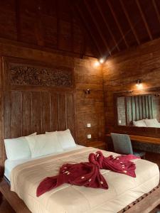 a bedroom with a bed with a red blanket on it at Penginapan Gelar in Jembrana +17 photos
