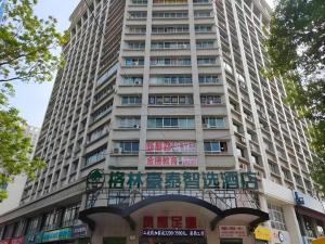 a tall building with a sign in front of it at Green Tree Inn Luoyang Fenghuang Mansion Mudan Square Metro Station in Luoyang