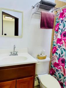 a bathroom with a sink and a toilet and a mirror at Hotel Coastalbay 2 & Golf Cart Rental in San Pedro +71 photos