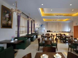 a restaurant with tables and chairs and a dining room at Vienna Hotel Guangdong Shaoguan Ruyuan Yao Cultural Square in Shaoguan