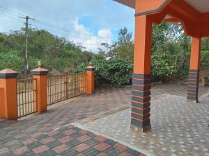 an orange fence with an orange pillar in a driveway at Lakshmi Nilaya Family Homestay on Hilltop-360 Degree View in Madikeri
