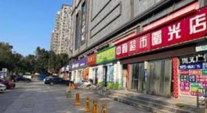 a building with signs on the side of a street at JTOUR Inn Wuhan Textile University in Wuhan