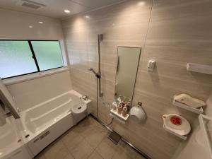 a bathroom with a shower and a toilet and a sink at 民泊絹家 in Izume +10 photos