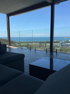Una sala de estar con vista al mar. en Mountain-Top Ocean View in Coffs Harbour, en Coffs Harbour