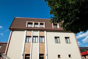 a tall white building with a brown roof at Luxe Stay in Târgu-Mureş