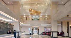 a lobby of a hotel with people standing in it at Vienna Hotel Zhengzhou Exhibition Center Zhengbian Road in Zhengzhou