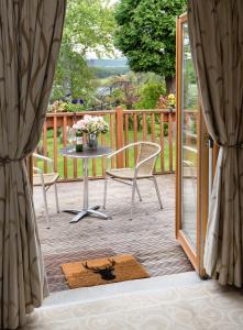 patio con tavolo e sedie su una terrazza di Boat Country Inn and Restaurant a Boat of Garten