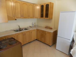 a kitchen with wooden cabinets and a white refrigerator at Elis apartment in Vlorë