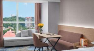 a hotel room with a table and a window at Grand Nest Hotel (Tang Jia Wan Beach) in Zhuhai