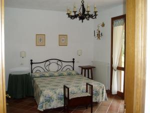 1 dormitorio con cama y lámpara de araña en Il Vivaio en Castiglione della Pescaia