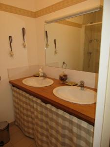 ein Badezimmer mit zwei Waschbecken und einem großen Spiegel in der Unterkunft La Closerie in Saint-Nizier-le-Bouchoux