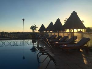 a row of lounge chairs next to a swimming pool at RL Ciudad de Úbeda in Úbeda