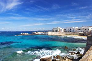 a beach with a group of buildings and the ocean at Suitedelmare in Gallipoli