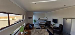 a living room with a table and chairs and a television at Namib's Edge in Swakopmund
