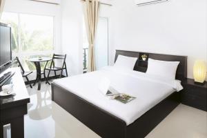 a bedroom with a bed and a table with chairs at Baan Payai Resort in Ban Pang Kae +55 photos