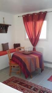 a dining room with a table and a red curtain at La Chambre De Salome in Collioure