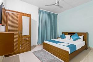 a bedroom with a bed with blue pillows and a mirror at SQUARE INN in Bengaluru