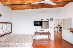 a bedroom with a bed and a tv and a table at Beautiful Beach House in Lo De Marcos, Nayarit! in Lo de Marcos