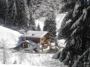 een huis bedekt met sneeuw in een besneeuwd bos bij Haus Kohler Bernhard in Nova Levante