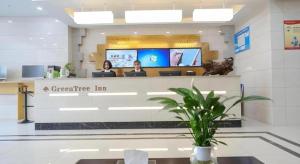 two people sitting at the counter of a dental office at GreenTree Inn Jiaxin Puyuan Kaixuan Road in Jiaxing