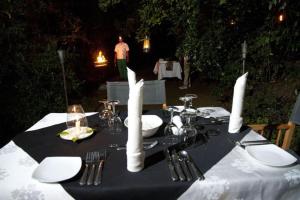 a table with white plates and forks and napkins at Explorer by Eco Team - Dambana in Mahiyangana