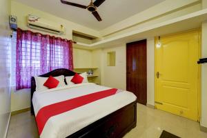 a bedroom with a large bed with red pillows at Hotel O Senthamizh Residency in Chennai +21 photos
