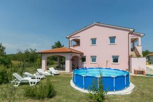 a house with a swimming pool in the yard at Apartment Elina in Labin