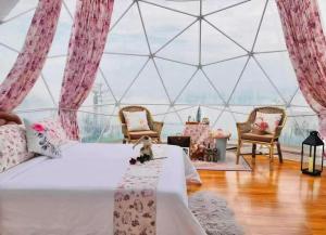 a room with a bed with a table and chairs at Phuchifa Sky Camp ร้อยรักภูชี้ฟ้า in Ban Seng Choi