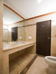 a bathroom with a toilet and a sink and a mirror at Makassar Golden Hotel in Makassar