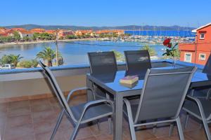 un tavolo e sedie su un balcone con vista sul porto di Luxury Apartments SIKIRIC with Fantastic View on the sea a Bibinje (Bibigne)