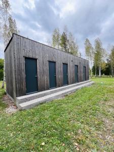 a building with four blue doors in a field at Kargevärava Elamustalu in Kapra