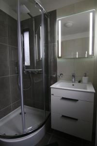La salle de bains est pourvue d'une douche, d'un lavabo et d'une baignoire. dans l'établissement Penzión Sibír, à Nový Smokovec