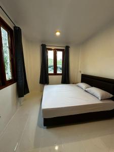 a large bed in a room with two windows at Hin Kong Hide Away 1 in Wok Tum