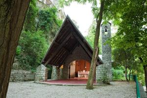 un edificio de piedra con una gran puerta en un bosque en Terme di Acquasanta Hotel Italia & Spa, en Acquasanta Terme