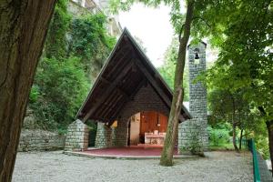 un edificio in pietra con una grande porta in una foresta di Terme di Acquasanta Hotel Italia & Spa ad Acquasanta Terme