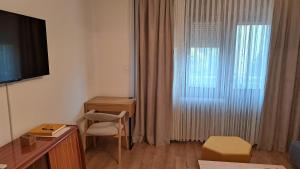 a hotel room with a desk and a window at Apartman 19 Vinkovci, klimatiziran, self check-in in Vinkovci