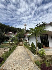 Un camino que conduce a un edificio blanco con árboles. en SODANY RESORT Kohrong, en Kaôh Rŭng (3)