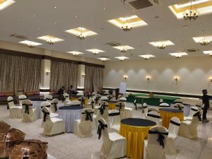 a banquet hall with tables and chairs and people at Hotel Grand Haveli in Achād