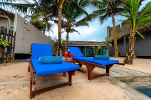 two blue chairs and a table on a beach at Paradise Shore House in Ambalangoda