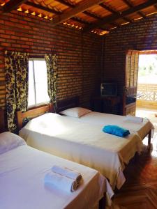 um quarto com duas camas e uma televisão em Pousada Sol e Mar em Parajuru