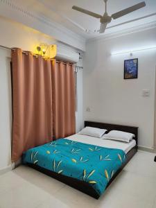 a bedroom with a bed with a blue comforter at Zivo Stays, Heritage Apartments, Rethibowli in Hyderabad