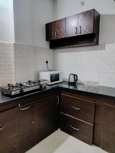 ハイデラバードにあるZivo Stays, Heritage Apartments, Rethibowliのコンロと電子レンジ付きのキッチン