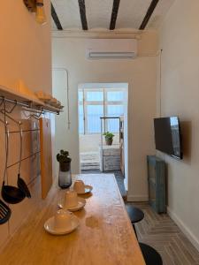 Chic & cozy Jaffa spot with a garden في تل أبيب: غرفة طعام مع طاولة وتلفزيون