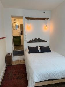 Chic & cozy Jaffa spot with a garden في تل أبيب: غرفة نوم بسرير أبيض ومرآة