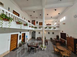 沙湾拿吉Monkey Guesthouse - Savannakhet的建筑物内有桌椅的房间