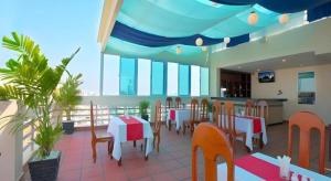 a restaurant with tables and chairs on a balcony at Kirirom Crystal Hotel in Phnom Penh