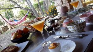una mesa con un vaso de zumo de naranja y comida en Om'Sleeping B&B, en Laudun